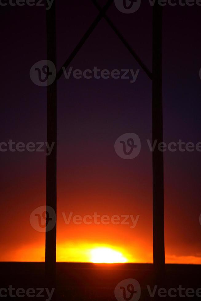 ondergaande zon tussen hydropalen in saskatchewan foto