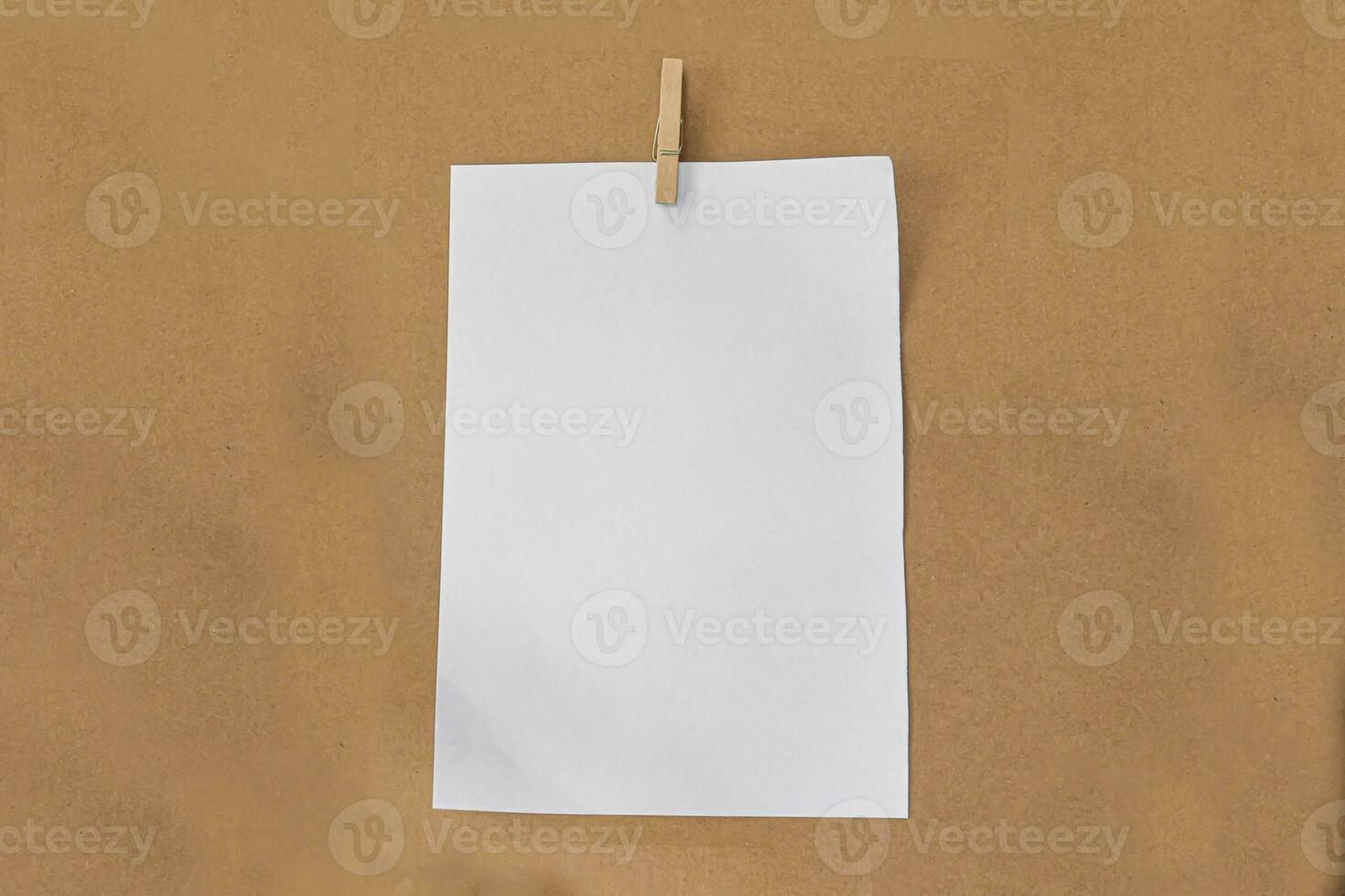 wit papier en houten clip op bruine papieren achtergrond. foto