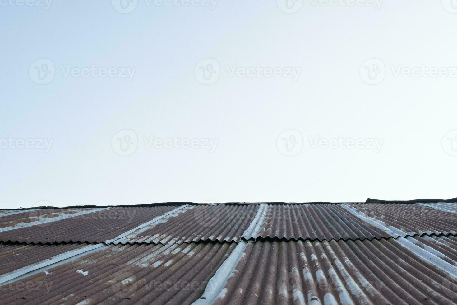 oud zinkroestdak en blauwe hemelachtergrond foto