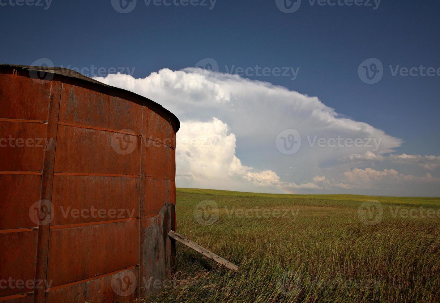 houten graanschuur met cumuloninumbuswolken op de achtergrond foto