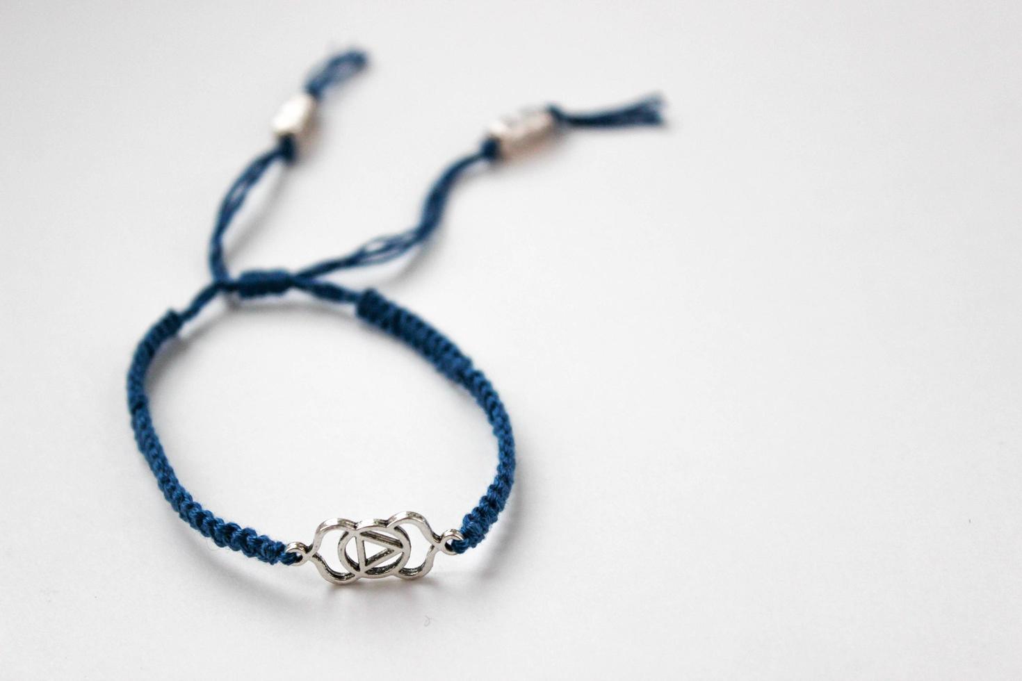 blauwe gevlochten armband met chakra ajna op witte achtergrond foto