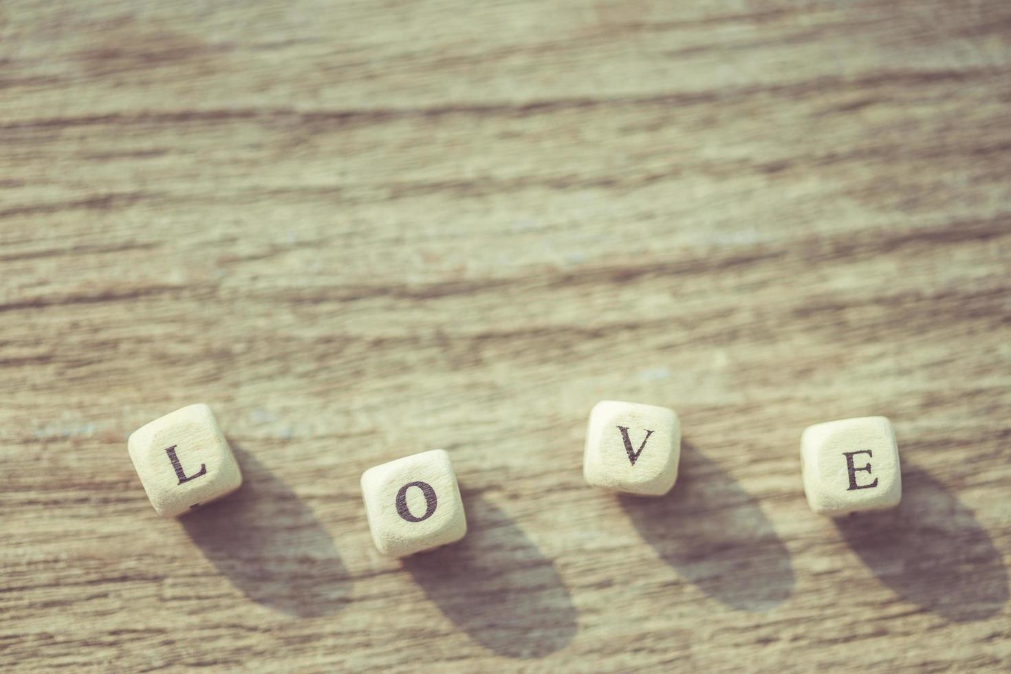 liefdeswoord van witte Engelse Alfabetletters op houten plank foto