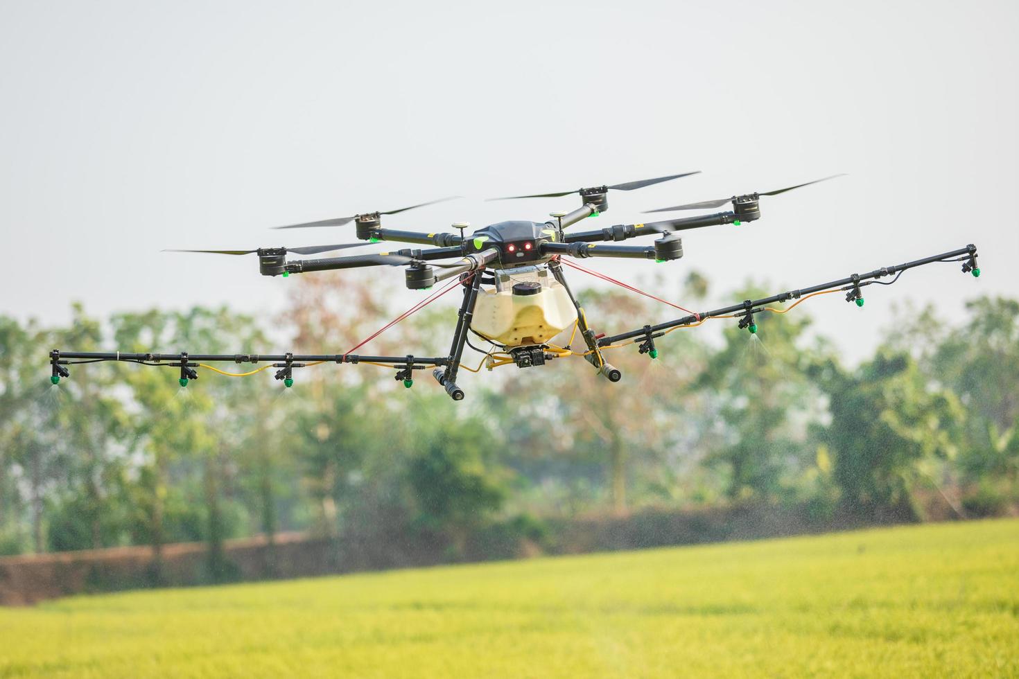 landbouwdrone die over het rijstveld vliegt om chemicaliën of kunstmest te spuiten. technologie voor landbouwconcept foto