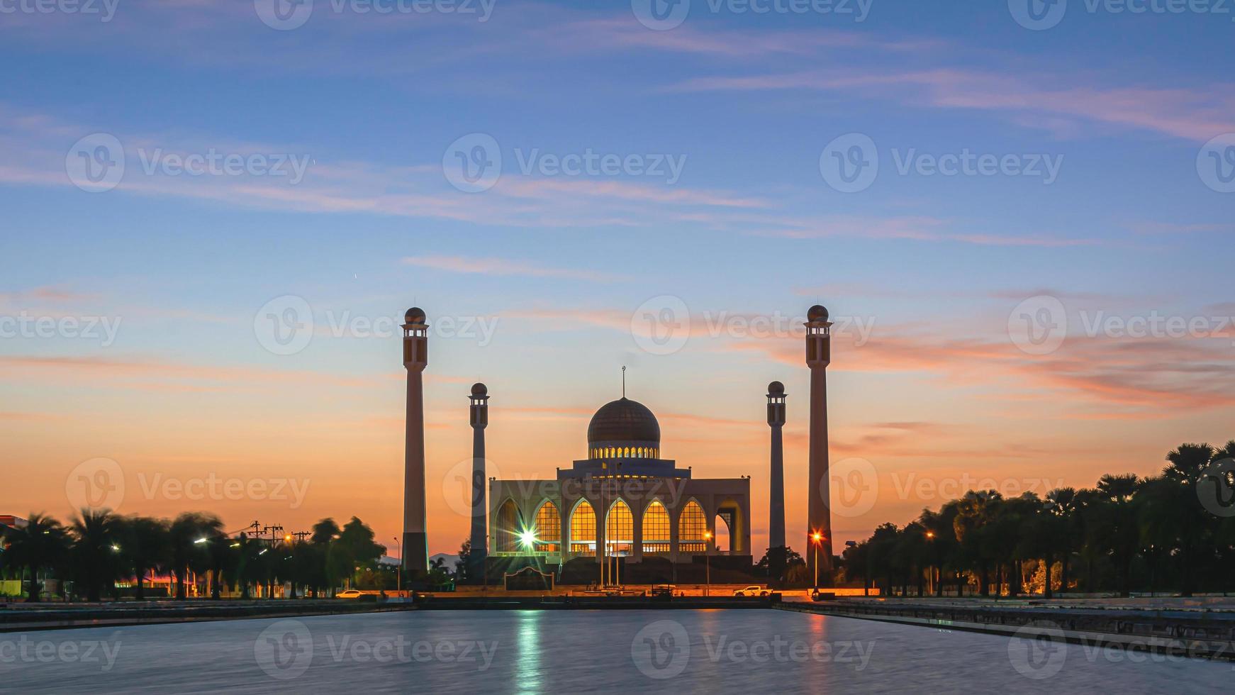 songkhla centrale moskee in dag naar nacht met kleurrijke luchten bij zonsondergang en de lichten van de moskee en reflecties in het water in het landschapsconcept van een oriëntatiepunt foto