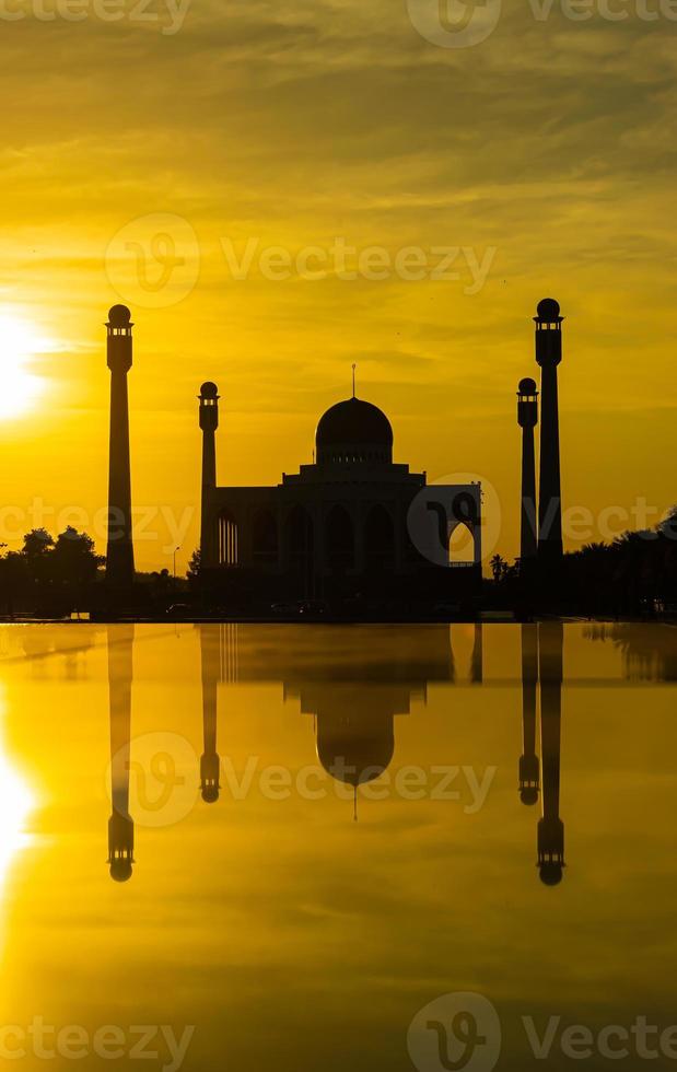 songkhla centrale moskee in dag naar nacht met kleurrijke luchten bij zonsondergang en de lichten van de moskee en reflecties in het water in het landschapsconcept van een oriëntatiepunt foto