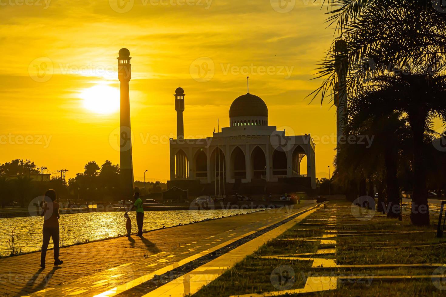 songkhla centrale moskee in dag naar nacht met kleurrijke luchten bij zonsondergang en de lichten van de moskee en reflecties in het water in het landschapsconcept van een oriëntatiepunt foto