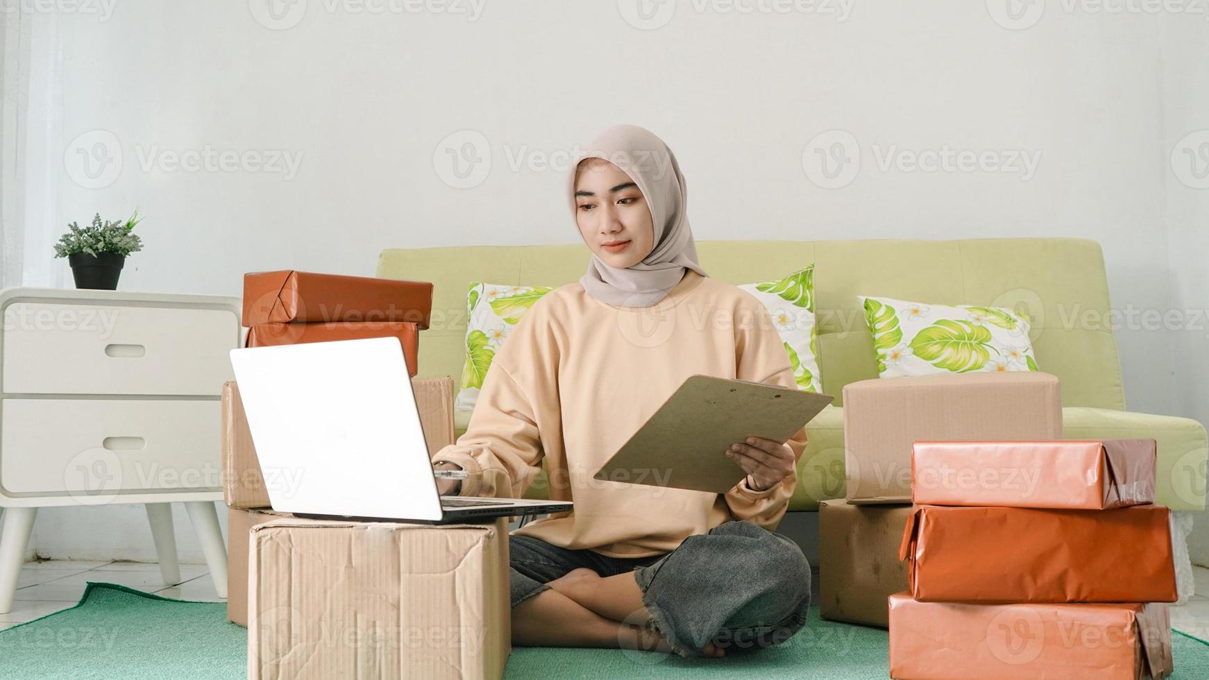jonge zakenvrouw die werkt met een laptop in de kamer foto