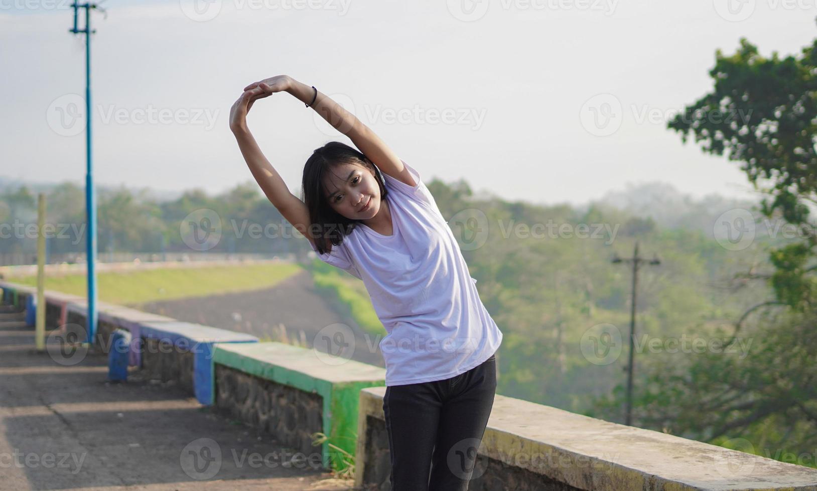 jonge aziatische vrouw strekt zich uit voordat ze 's ochtends jogt en rent foto