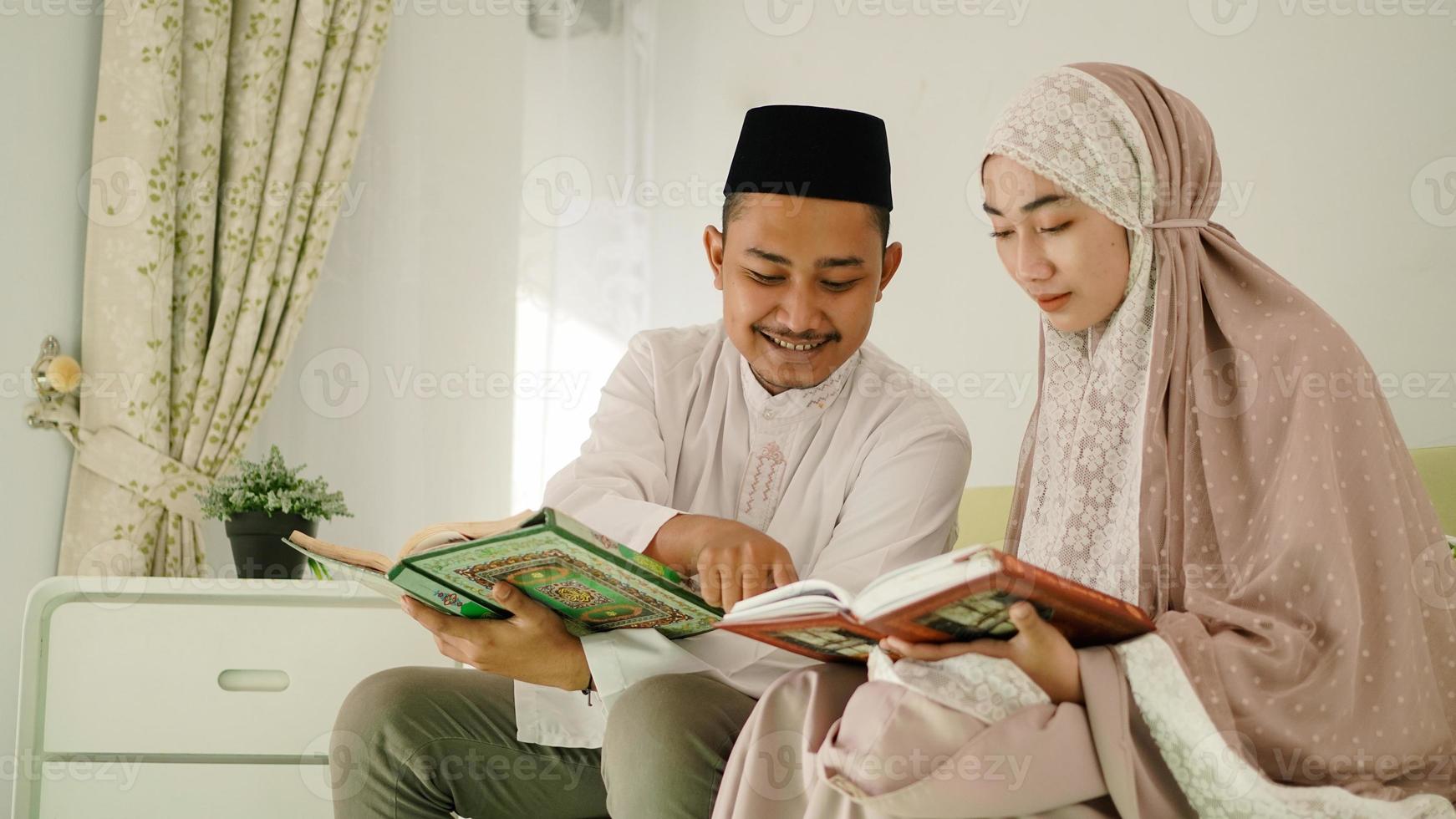 moslim man helpt zijn vrouw de koran te lezen foto