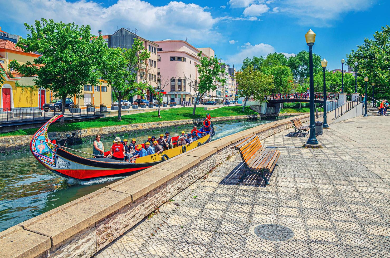 Aveiro, Portugal, 13 juni 2017 Aveiro Cityscape met traditionele kleurrijke Moliceiro-boot met toeristen die in smal waterkanaal varen foto