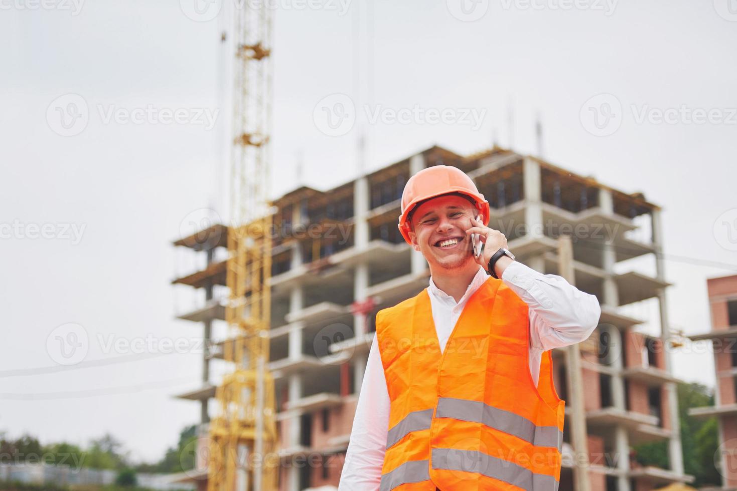 jonge architect die een beschermende helm draagt die zich op de bergen bevindt die buitenachtergrond bouwt foto