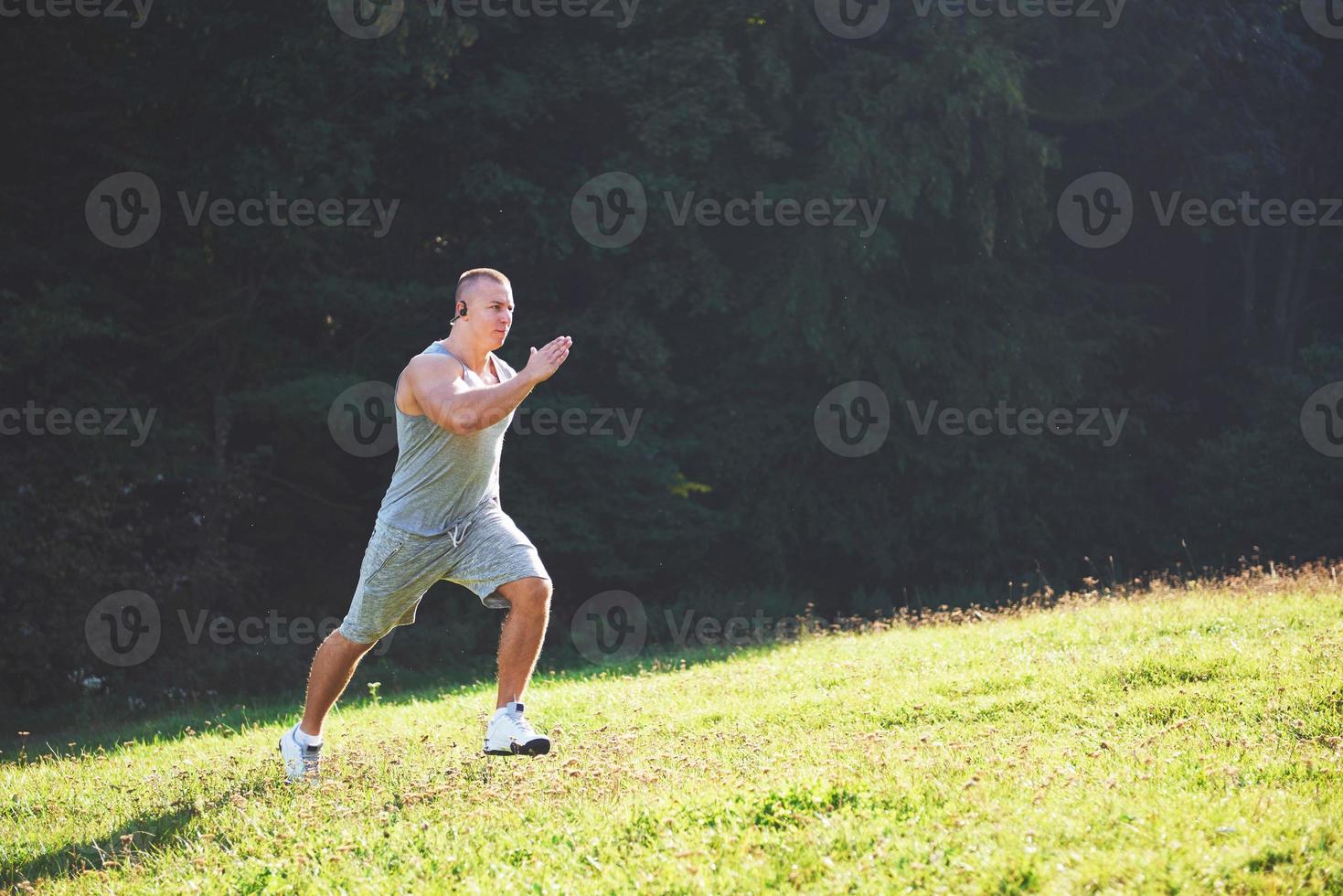 fitness man atleet joggen in de natuur tijdens zonsondergang. persoon die aan het trainen is, een actieve levensstijl leidt die cardio traint in de zomer in sportkleding en schoenen. foto