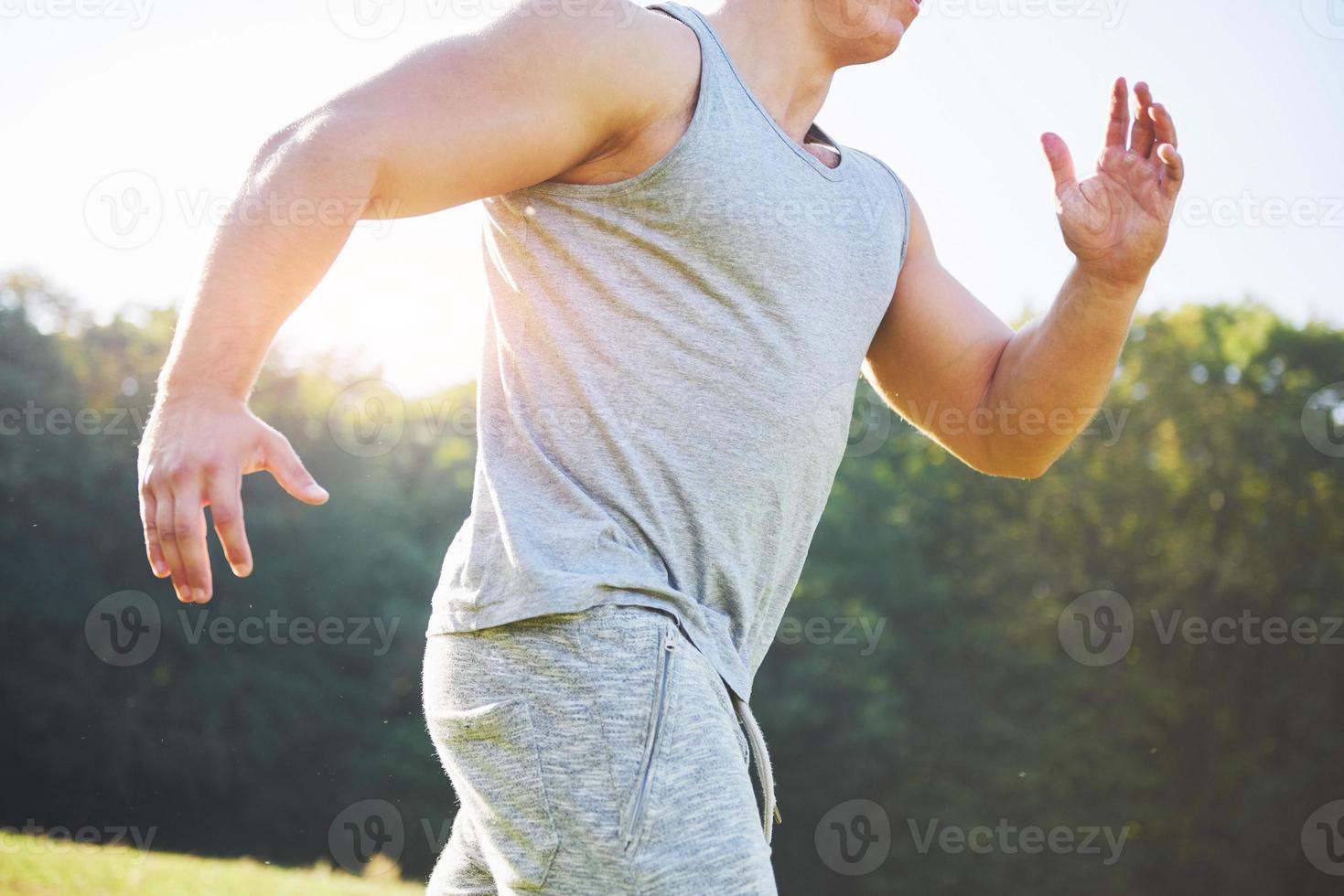 fitness man atleet joggen in de natuur tijdens zonsondergang. persoon die aan het trainen is, een actieve levensstijl leidt die cardio traint in de zomer in sportkleding en schoenen. foto