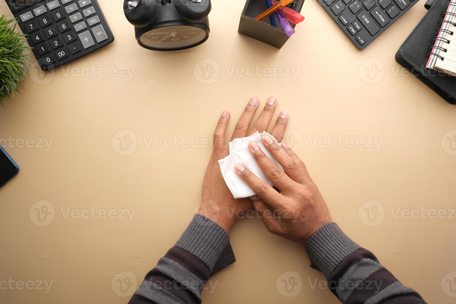 man desinfecteert zijn handen met een nat doekje. foto