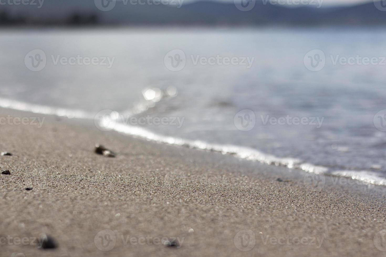 golf splash zee strand macro, close-up, close-up van zeeschuim en nat zand. foto