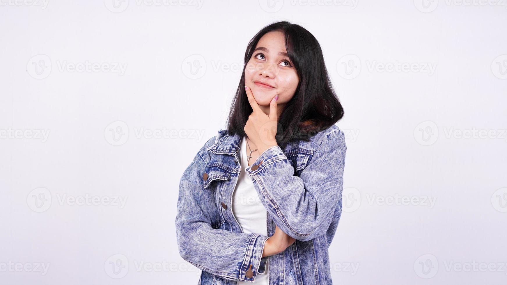 Aziatische vrouw die lacht met een spijkerjasje en een idee denkt met een geïsoleerde witte achtergrond foto