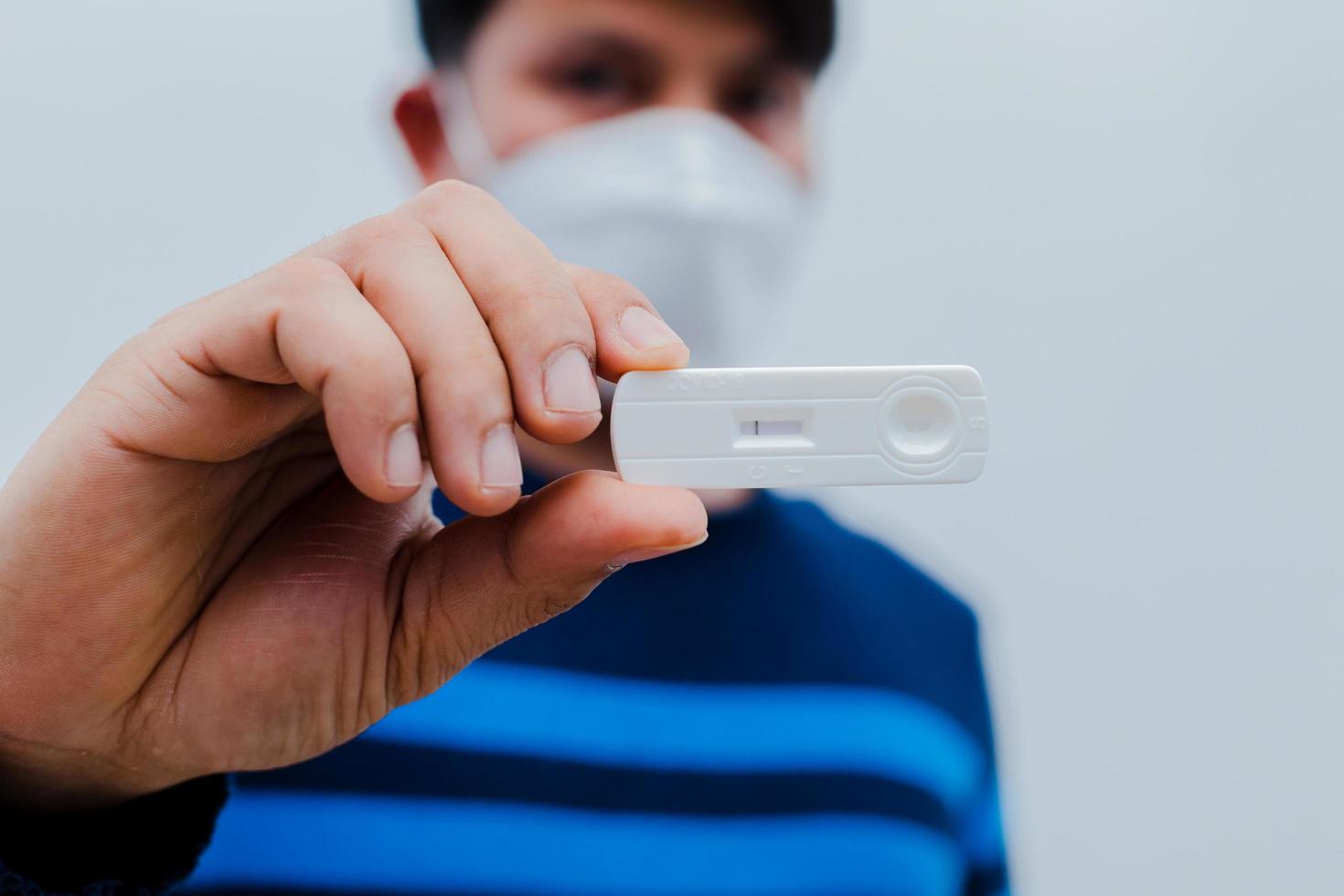 man met snelle antigeentestkit met positief resultaat tijdens covid-19-testen met uitstrijkje. foto