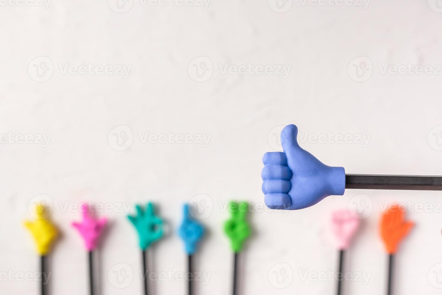 groep speelgoed duim omhoog handgebaar op potlood met witte pasta concrete achtergrond foto