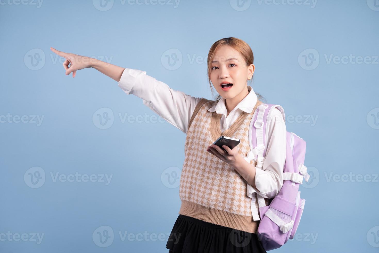 jong Aziatisch middelbare schoolmeisje op blauwe achtergrond foto