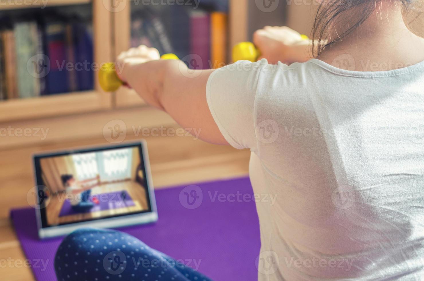 jonge aantrekkelijke vrouw in sportkleding die thuis traint foto