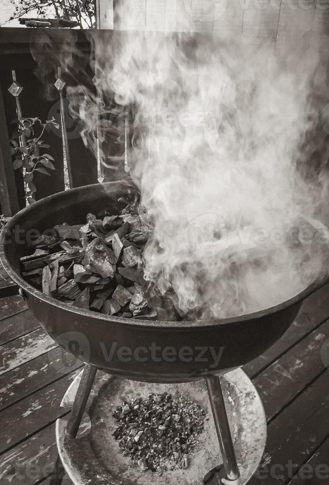 gloeiende barbecue houtskoolvuur rook bij het aanzetten van de barbecue noorwegen. foto