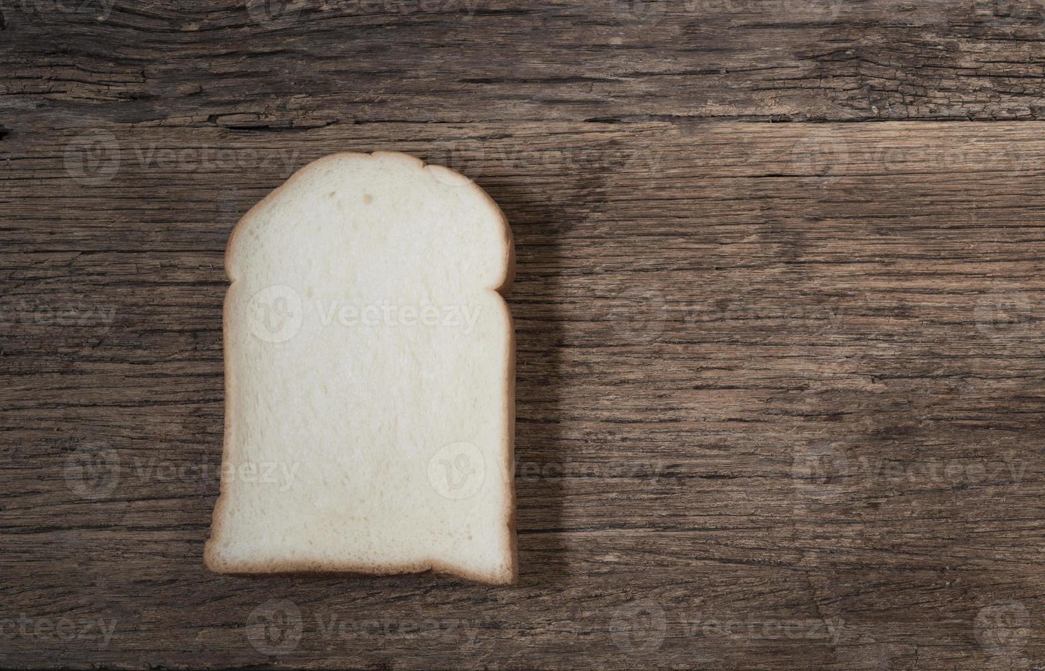 wit brood sneetje geïsoleerd op hout achtergrond foto