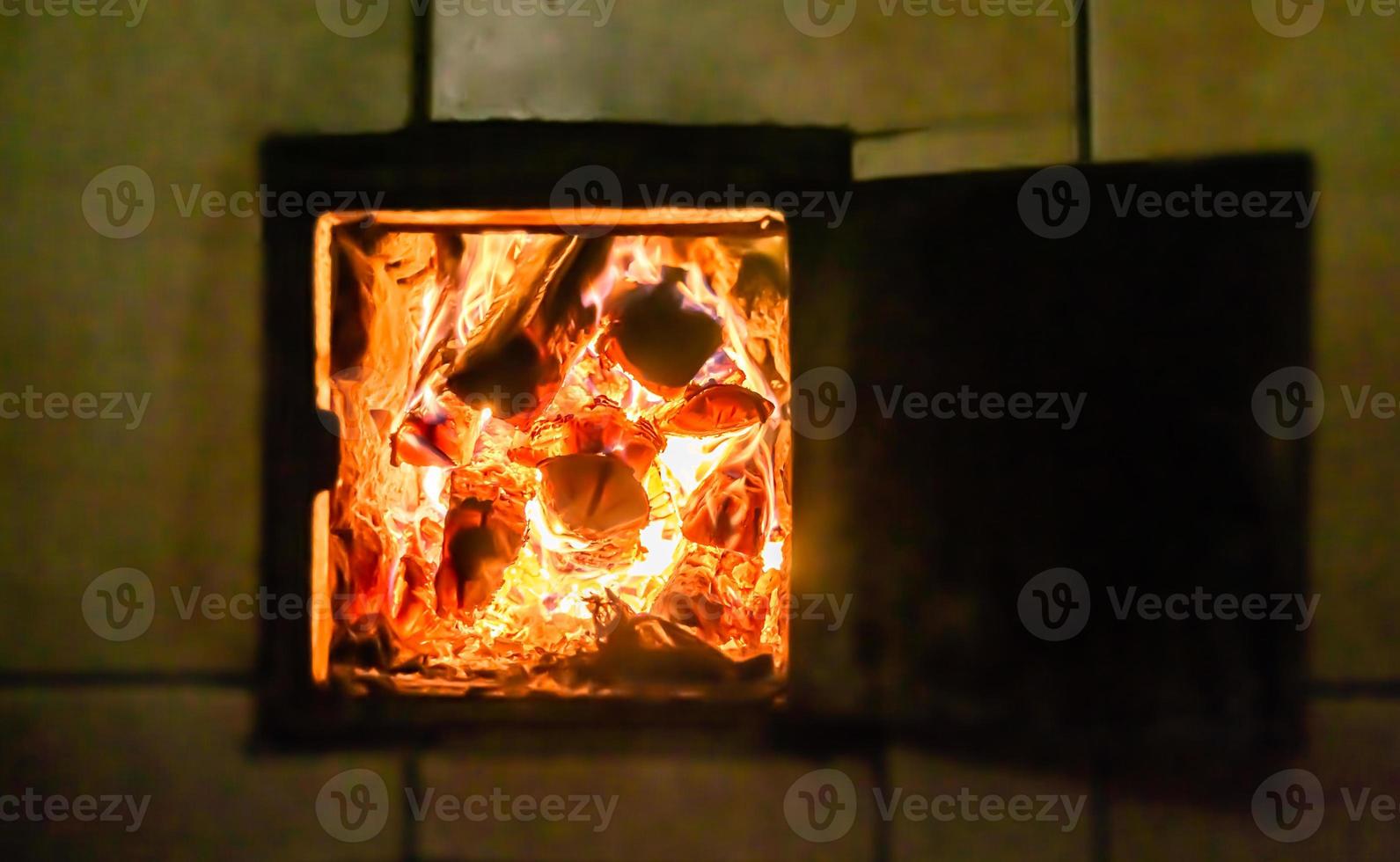 mooie oude open haard met licht vlamvuur voor het verwarmen van de bouwkamer foto