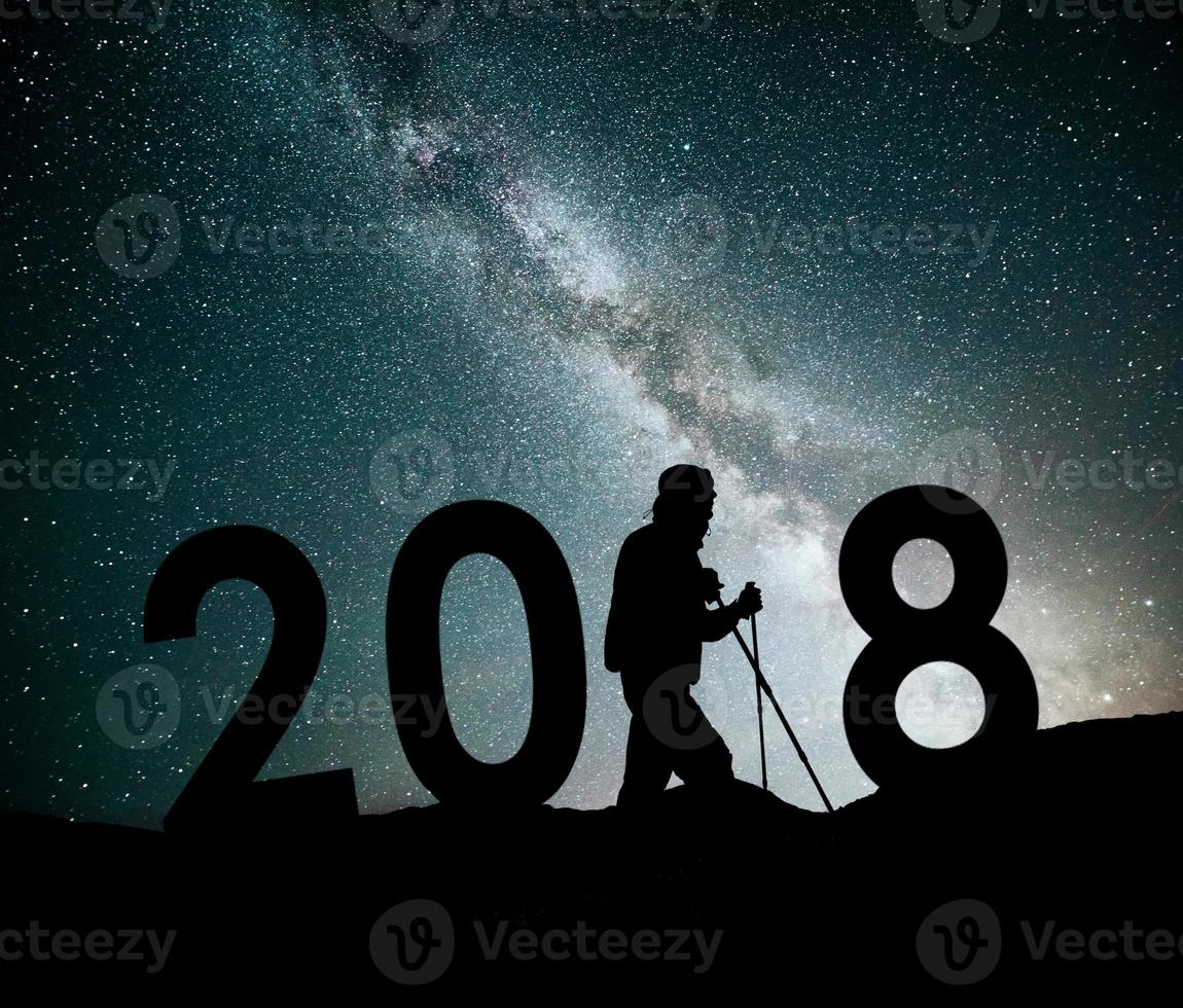 silhouet jonge wandelaar man voor 2018 nieuwjaar achtergrond van de Melkweg op een heldere ster donkere hemel toon foto