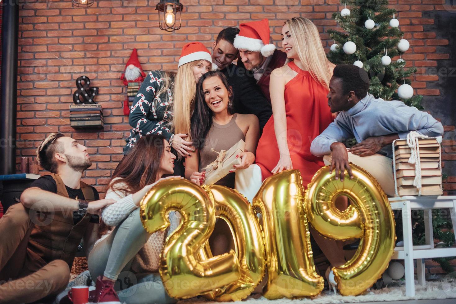 groep vrolijke oude vrienden communiceren met elkaar. het nieuwe jaar van 2019 komt eraan. het nieuwe jaar vieren in een gezellige huiselijke sfeer foto