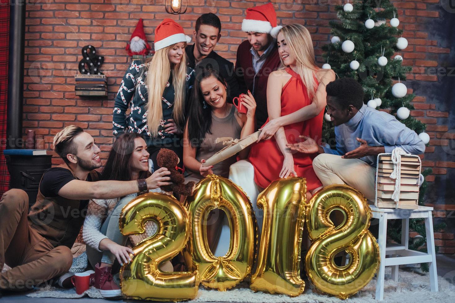 groep vrolijke oude vrienden communiceren met elkaar. het nieuwe jaar van 2018 komt eraan. het nieuwe jaar vieren in een gezellige huiselijke sfeer foto