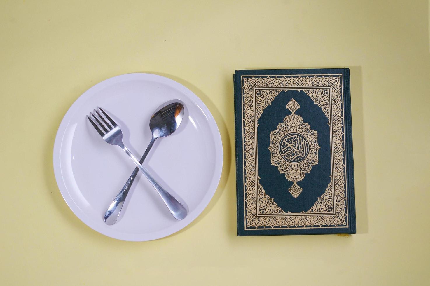 leeg bord met lepel en al-koran, ramadan-concept foto