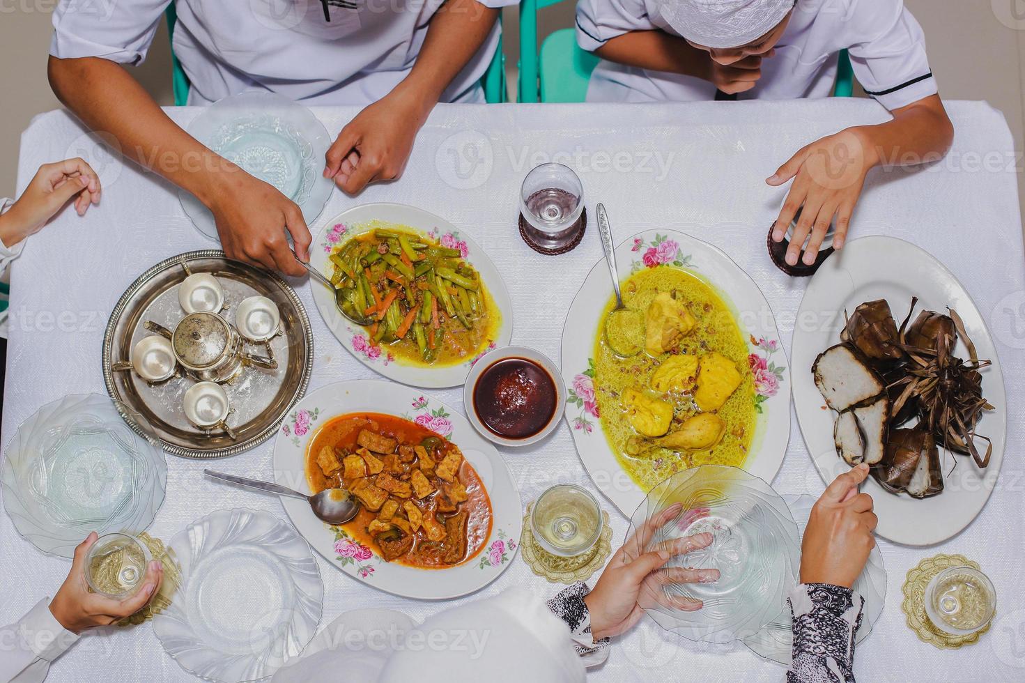 bovenaanzicht van ketupat lebaran, indonesisch traditioneel feestgerecht van rijstwafel met verschillende bijgerechten geserveerd op tafel tijdens eid mubarak foto