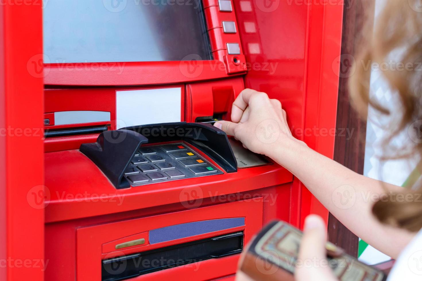 vrouw gebruikt een creditcard bij atm close-up foto