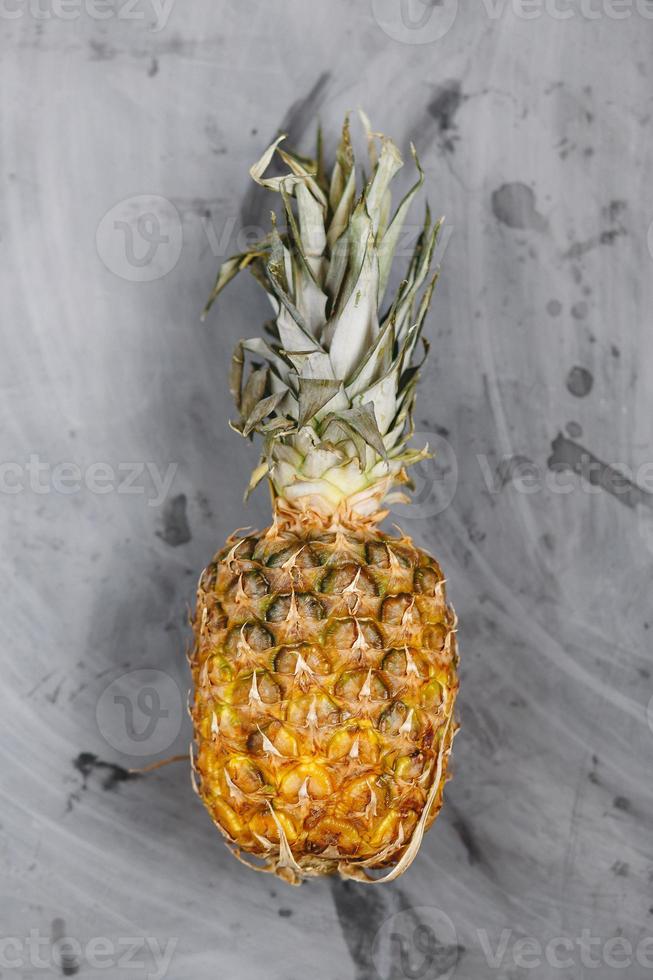 rijpe hele ananas op grijze betonnen ondergrond. foto