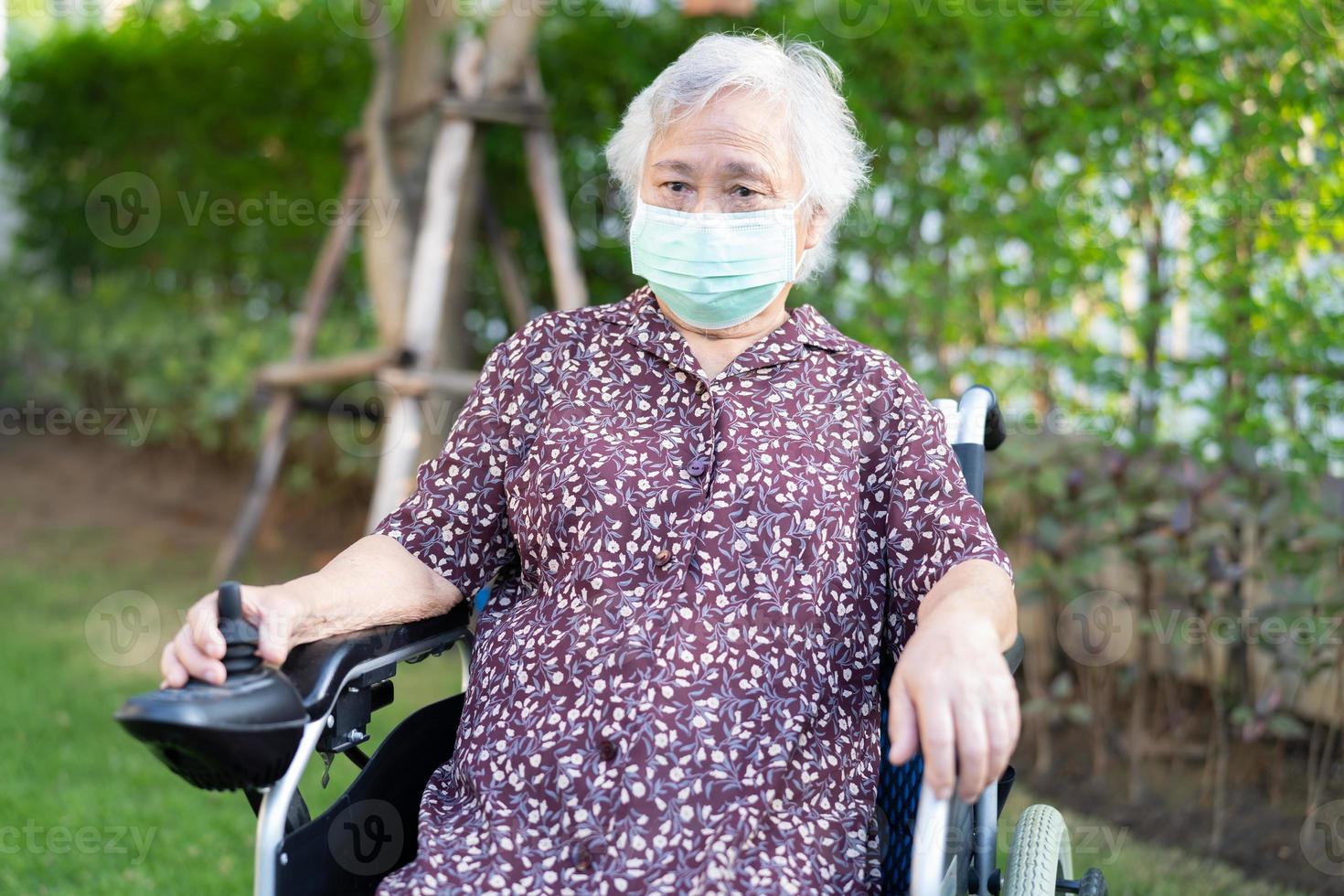 aziatische senior of oudere oude dame vrouw patiënt op elektrische rolstoel met afstandsbediening en het dragen van een gezichtsmasker ter bescherming van de veiligheidsinfectie covid 19 coronavirus. foto