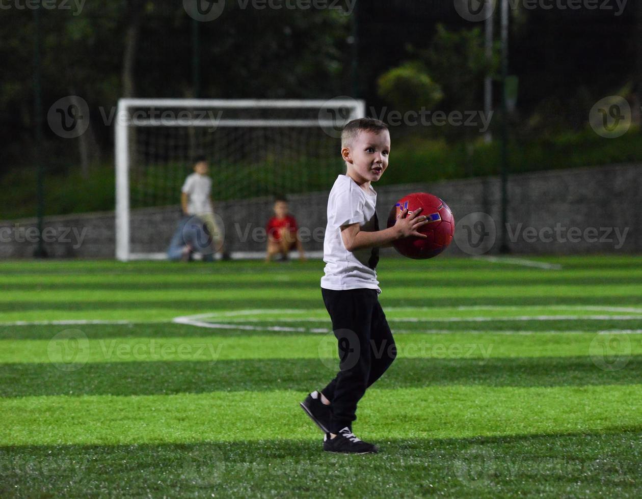 kleine jongen die met de bal speelt foto