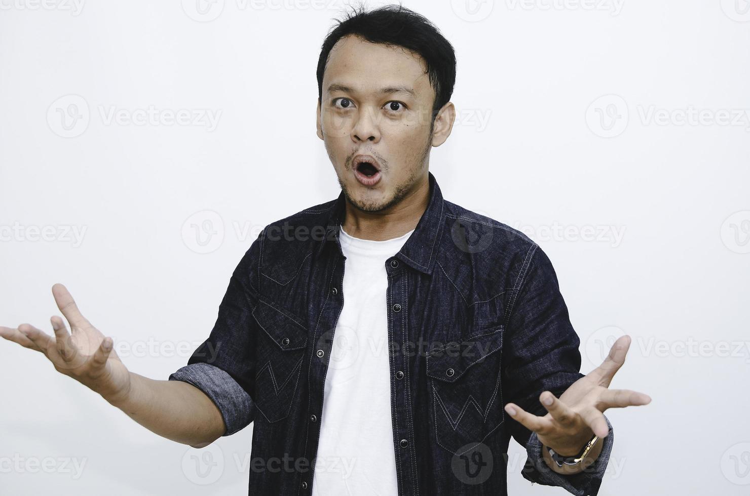 wow en geschokt gezicht van jonge aziatische man met open handgebaar. reclame model concept. foto