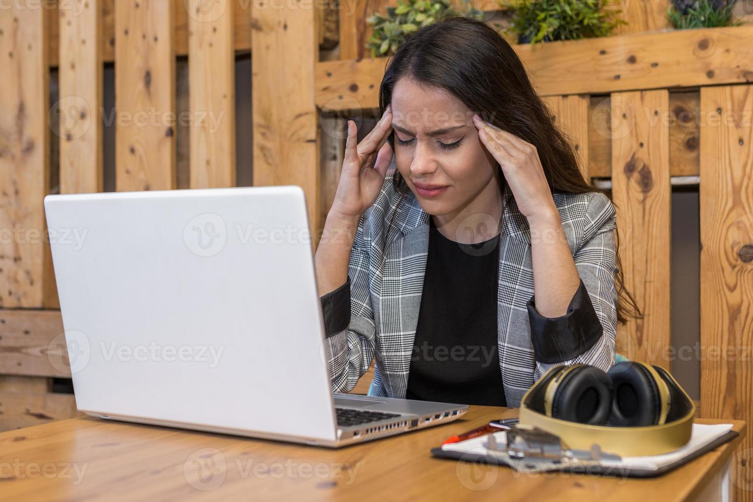 uitgeputte vrouw die aan laptop in café werkt foto