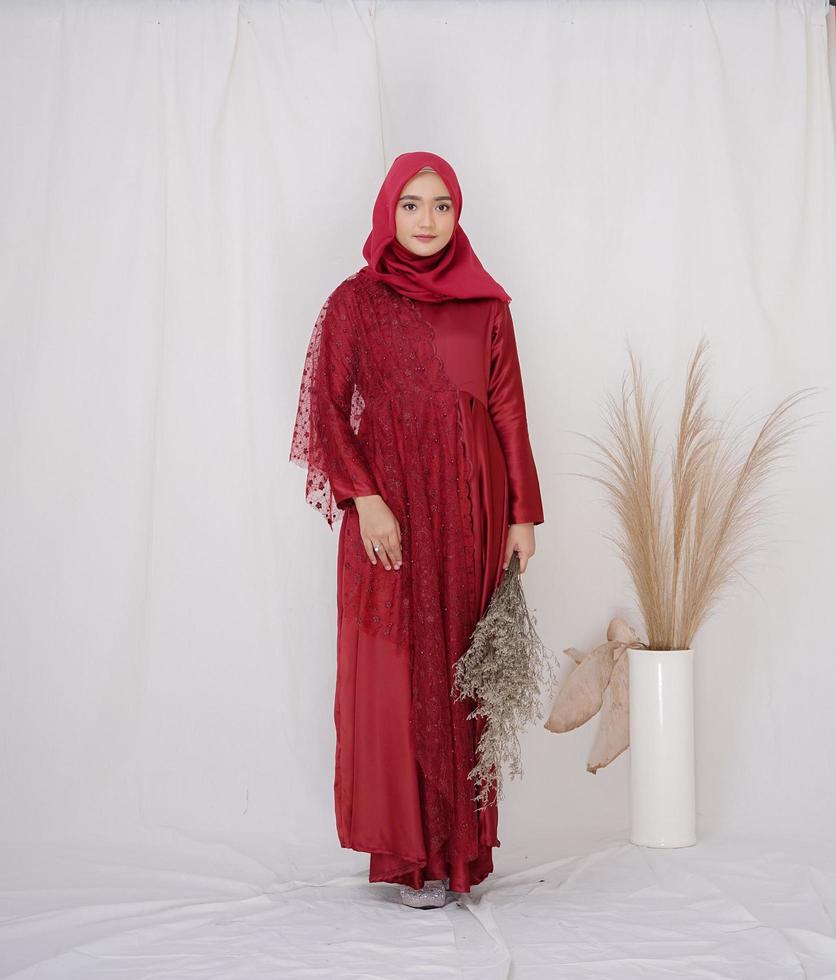 mooi islamitisch vrouwelijk model met hijab-mode, een moderne lifestyle-outfit voor moslimvrouw. concept een trouwjurk, schoonheid of eidul fitri. een Aziatisch meisjesmodel dat hijab draagt tijdens een fotoshoot binnenshuis foto