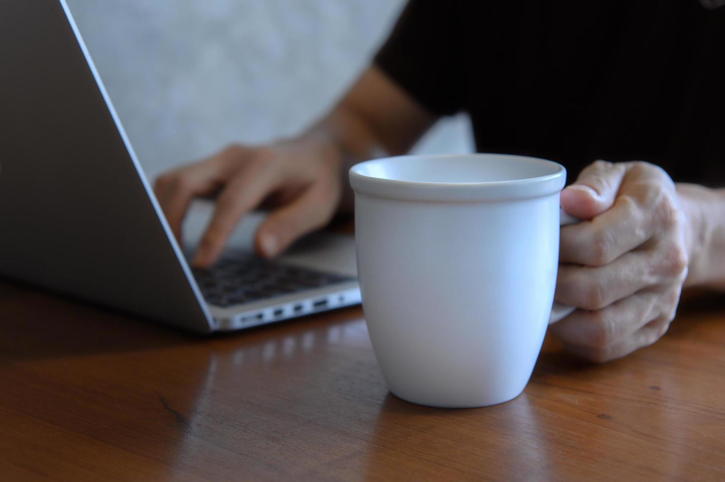 freelancer zittend in een coffeeshop aan een houten tafel foto