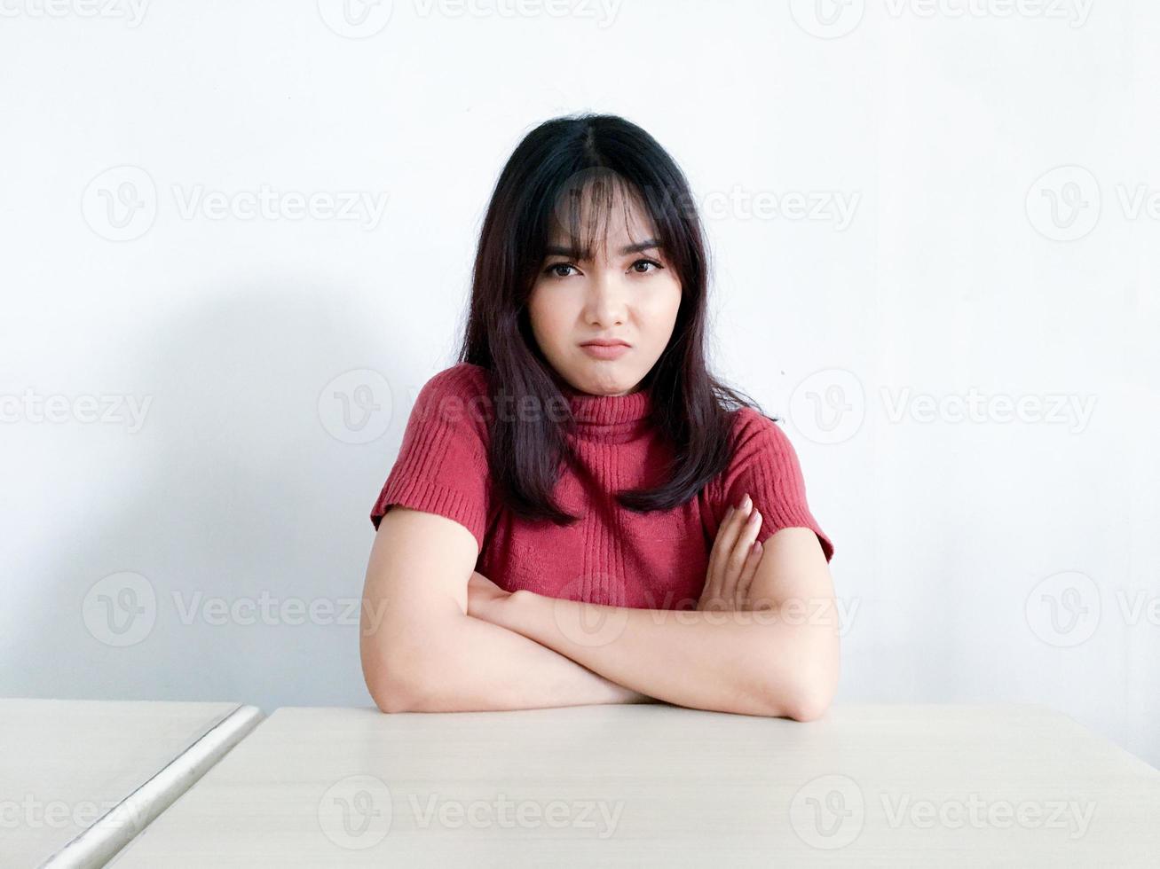 mooi Aziatisch meisje is boos en boos met gevouwen armen geïsoleerd op een witte achtergrond. foto