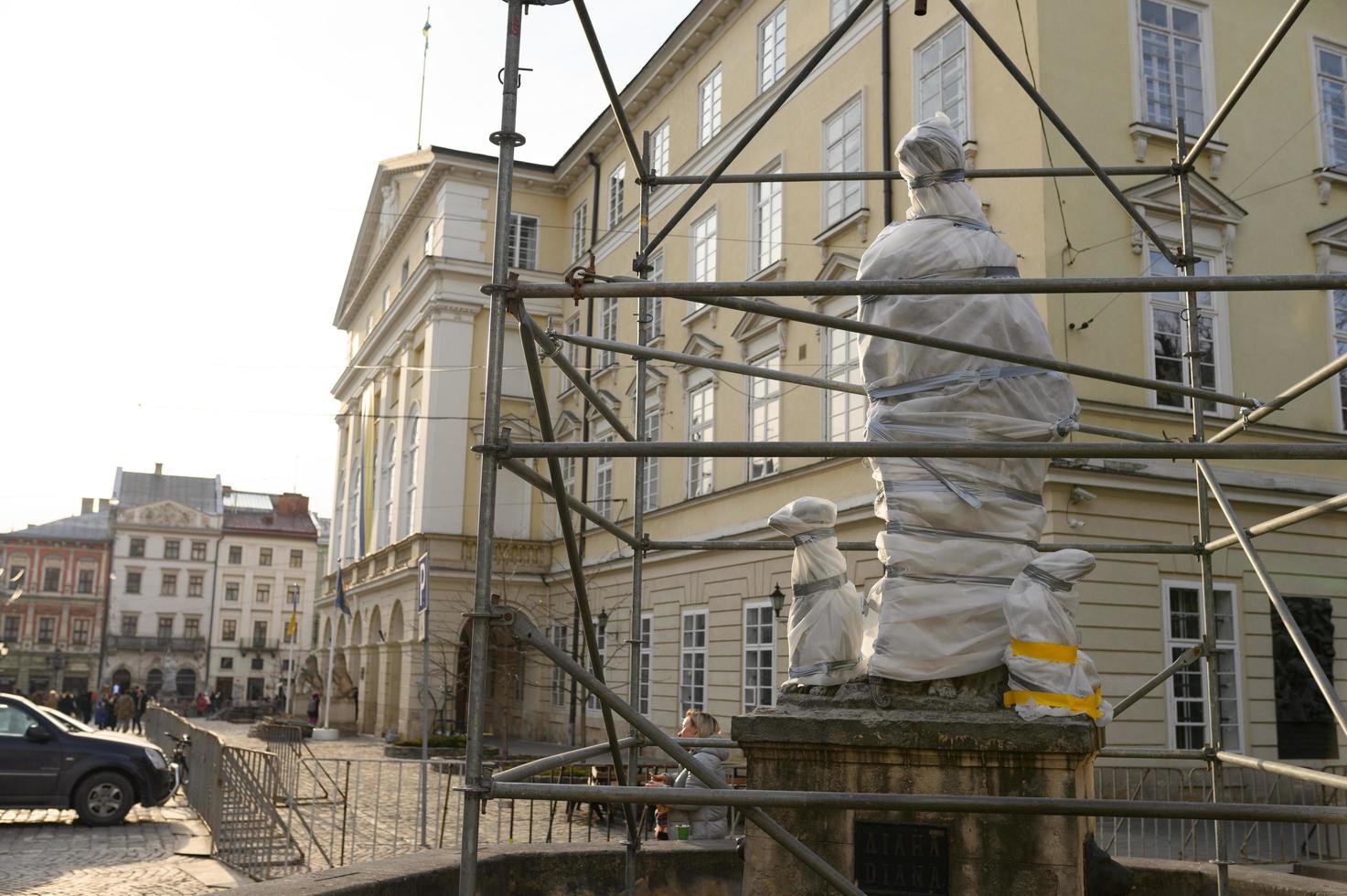 lviv, oekraïne maart. 12, 2022 oorlog in oekraïne. in lviv worden monumenten en gebouwen van historische waarde voorbereid op een mogelijk bombardement. sculpturen zijn bedekt met een beschermende film foto