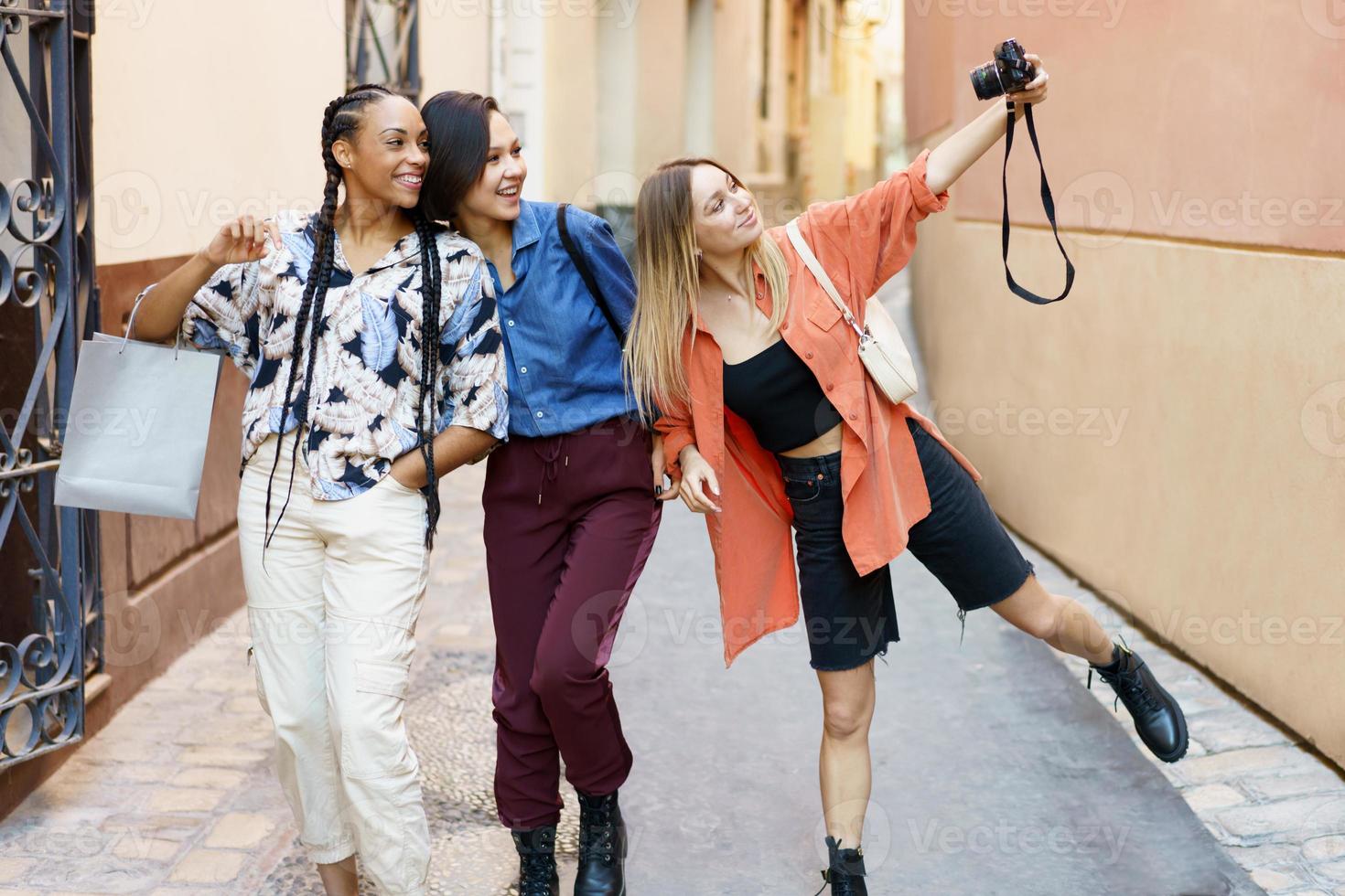 gelukkige diverse dames die selfie op camera nemen tijdens een reis in de stad foto