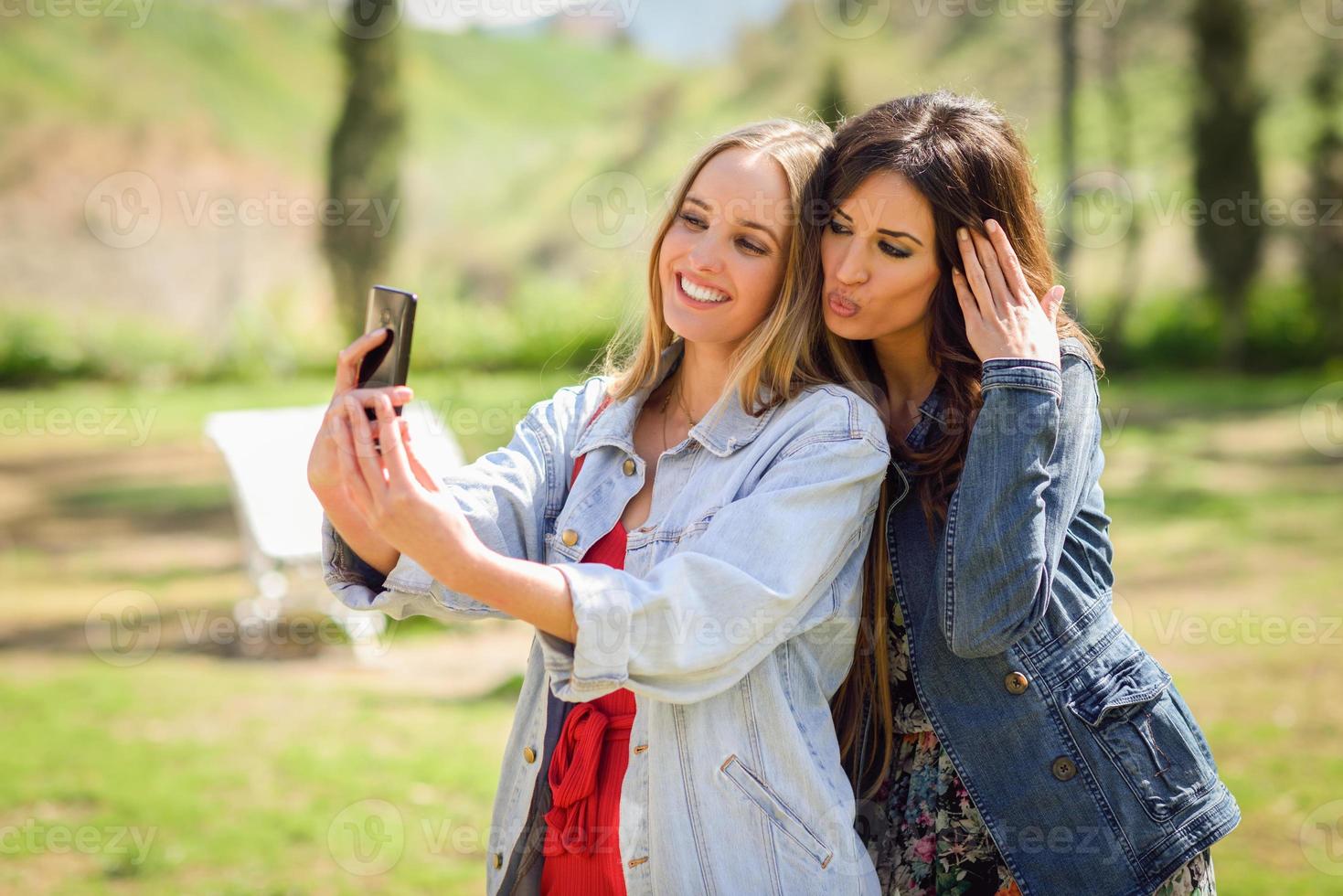 twee jonge vrouwen die een selfie-foto maken in het stadspark foto