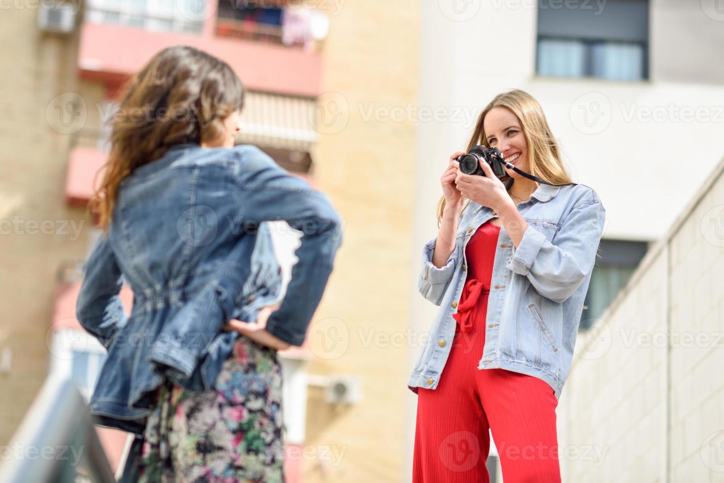 twee jonge toeristenvrouwen die buiten foto's maken foto