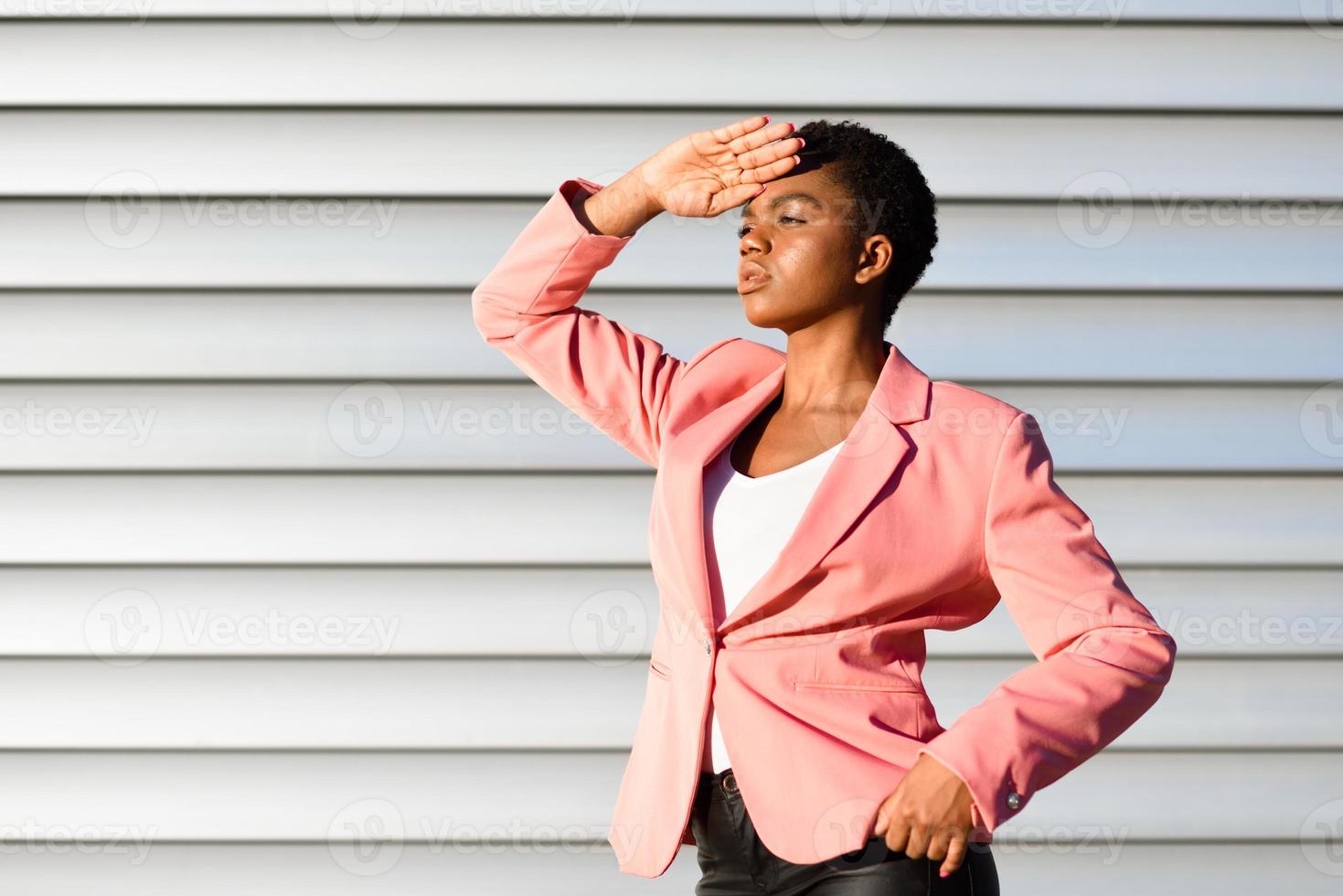 zwarte vrouw, model van mode, staande op stedelijke muur foto