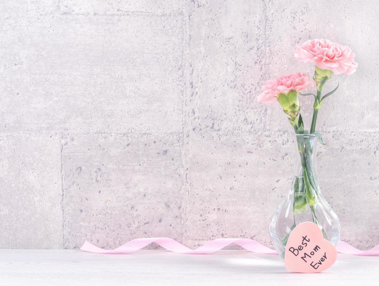 Moederdag handgemaakte geschenkdoos verrassingswensen fotografie - mooie bloeiende anjers met roze lintdoos geïsoleerd op grijs behangontwerp, close-up, kopieer ruimte foto
