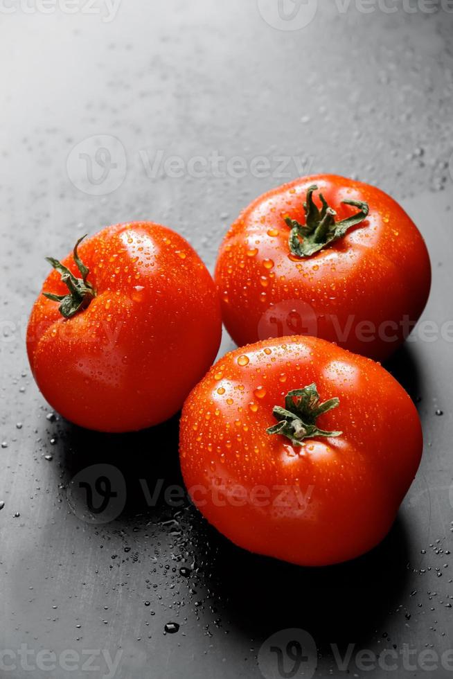 grote rode tomaten met druppels water. foto