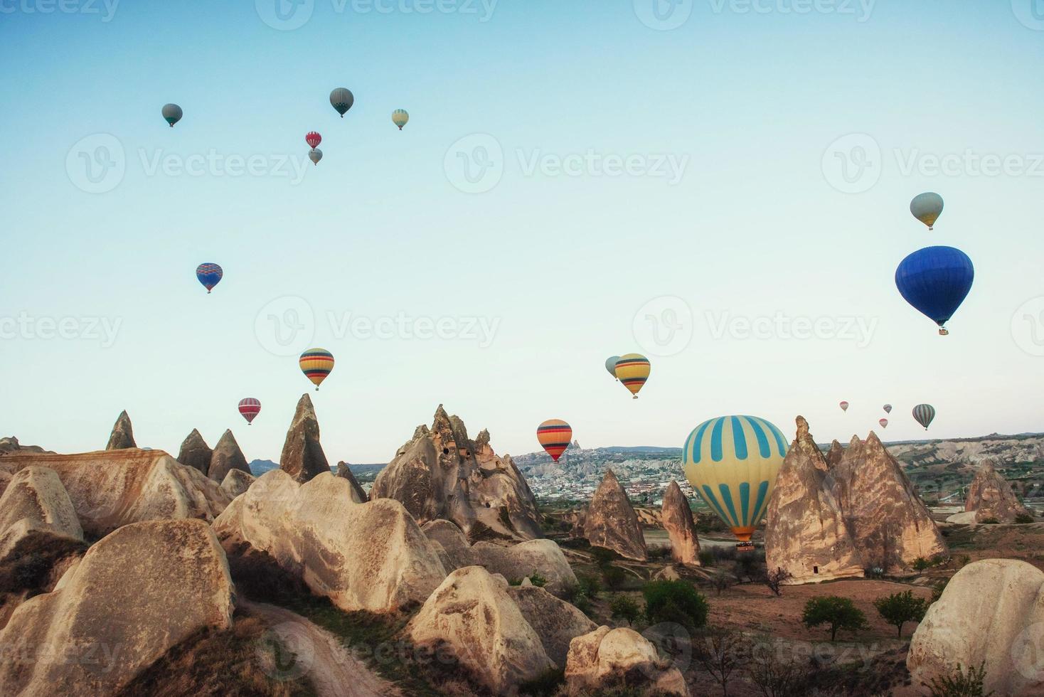 hete luchtballon die over rotslandschap in Cappadocia Turkije vliegt. foto