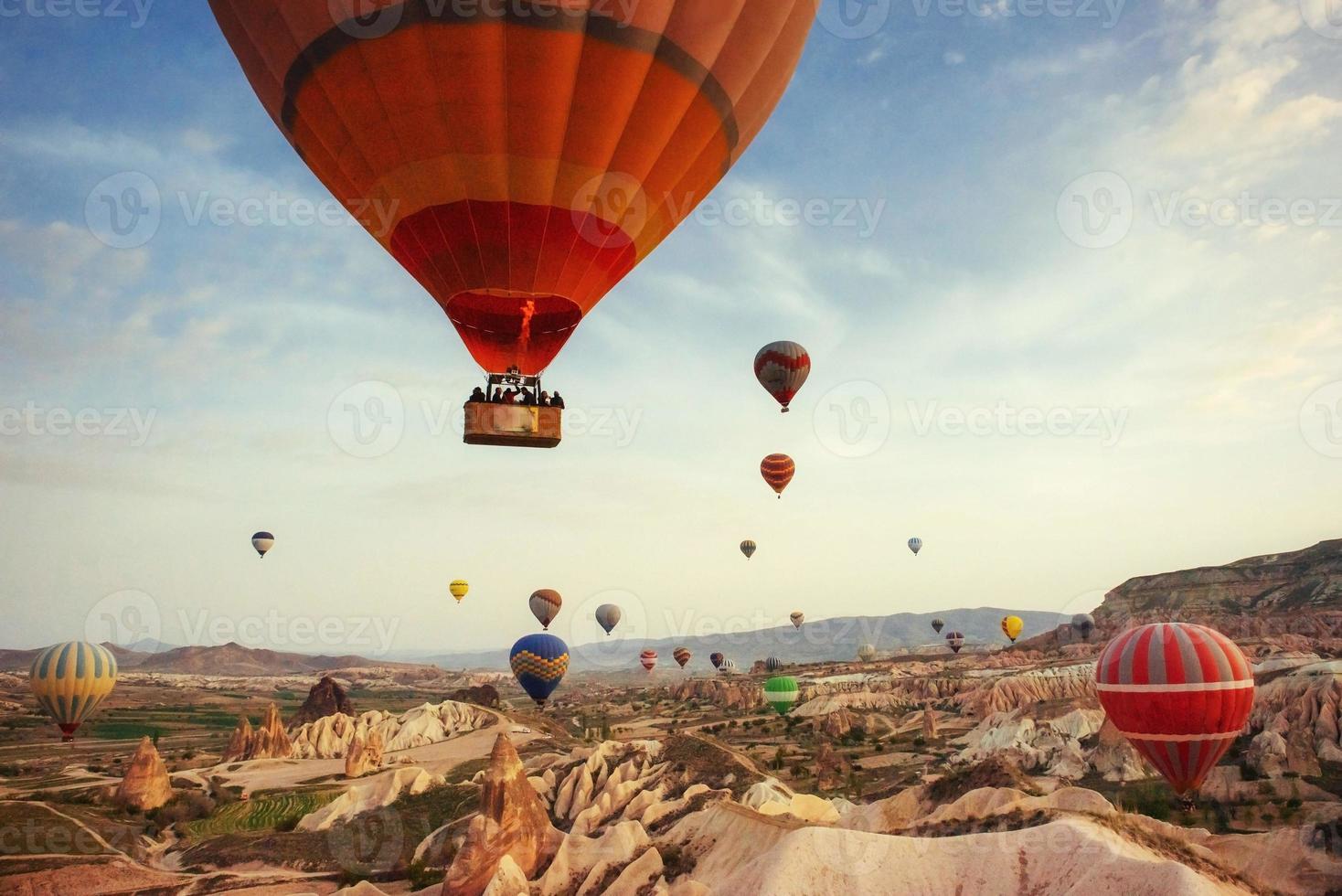 kleurrijke heteluchtballonnen die over rode vallei in cappadocië vliegen, foto